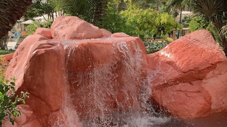 Photo Yes, pool builders can create pool designs that accommodate water features like waterfalls or grottos